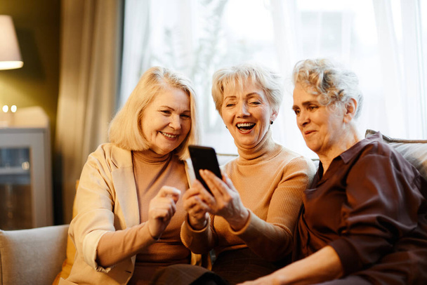 Τρεις ηλικιωμένες γυναίκες που χρησιμοποιούν κινητό τηλέφωνο - Φωτογραφία, εικόνα