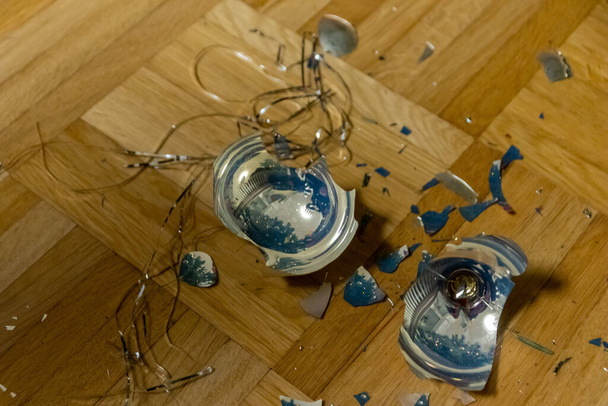 Зламані різдвяні кульки на землі були знищені дітьми напередодні Різдва під час прикраси ялинки сім'єю і повинні бути збиті мітлою, щоб очистити і прикрасити її.
 - Фото, зображення