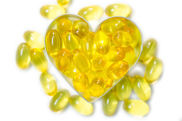 fish oil pills on heart shape box on white background isolated - Photo, Image