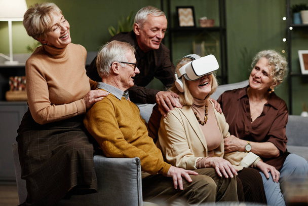 Aged woman using VR glasses - Foto, afbeelding