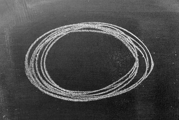 Dibujo de mano de tiza blanca como forma de círculo sobre fondo de tablero negro
 - Foto, Imagen