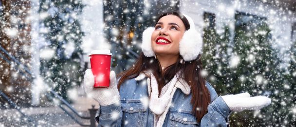 Joyeux jeune femme avec une tasse de café le jour neigeux - Photo, image