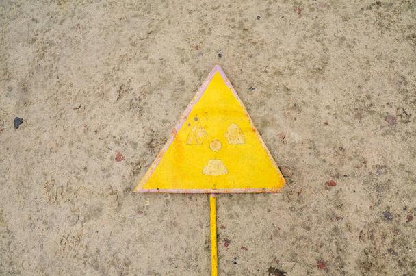 Porzucony stary żółty znak ostrzegawczy przed promieniowaniem jądrowym w strefie wykluczenia w Czarnobylu, Ukraina  - Zdjęcie, obraz