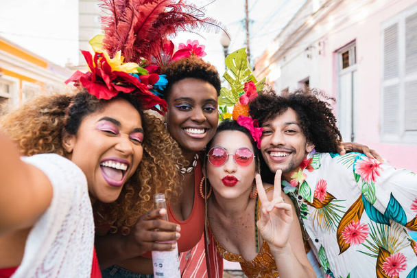 Φίλοι με κοστούμια διασκεδάζουν στο πάρτι του καρναβαλιού στο δρόμο. Βραζιλία διακοπές διασκέδαση selfie με την ομάδα των ανθρώπων μαζί - Φωτογραφία, εικόνα