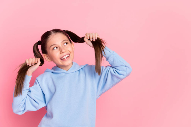Portrait of attractive cheerful curious preteen girl making tails having fun copy space isolated over pink pastel color background - Фото, изображение