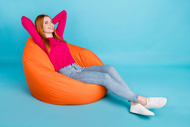Plná délka tělo velikost pohled na atraktivní veselá dívka ležící odpočívá v tašce židle izolované přes živé modré barvy pozadí - Fotografie, Obrázek