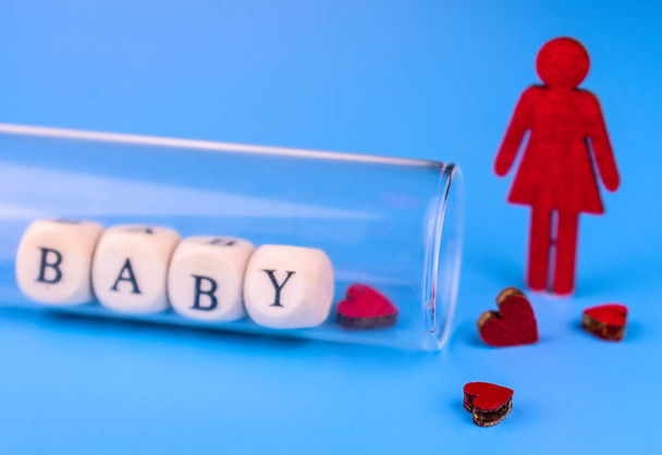 Mulher solitária e tubo de teste de laboratório com lettering bebê. Conceito de inseminação artificial. - Foto, Imagem