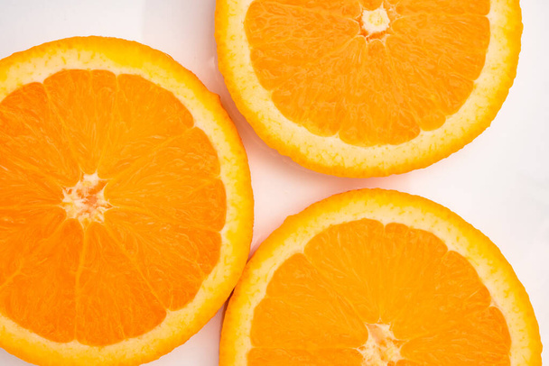 Fresh sliced oranges on a light background - Fotó, kép