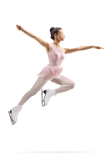 Full length shot of a professional female figure skater in a pink dress jumping isolated on white background - Zdjęcie, obraz