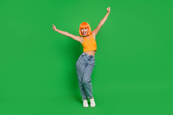 Full length photo of happy nice young woman raise hands winner celebrate isolated on green color background - Foto, imagen