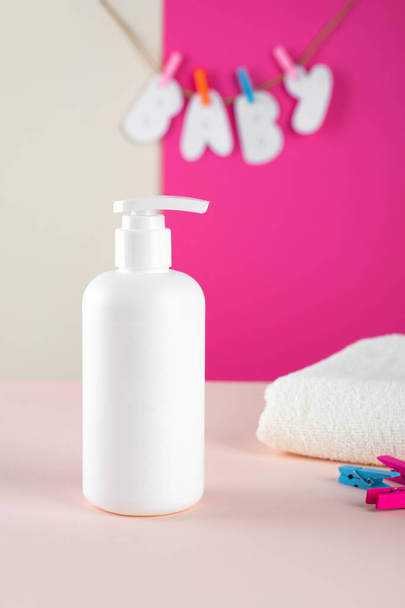 Natural Hypoallergenic Foam for bathing children. White Plastic pump bottle. childrens cosmetics. Bottles on a minimalistic fuchsia - pink background and a soft towel. Mock up. - Фото, изображение