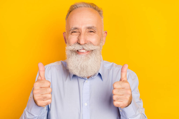 Photo of happy positive old man hold hands thumbs up recommend good product isolated on yellow color background - Foto, imagen