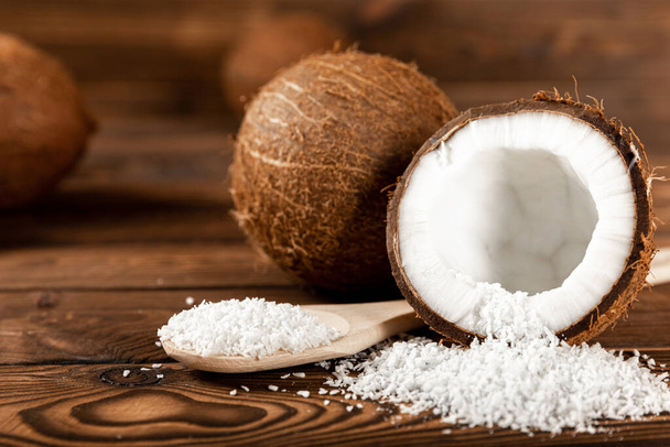 coconut flakes on a wooden spoon, coconuts on a wooden background. Close-up. copy space. - Foto, Imagem