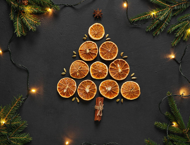 dried orange slices lai in the form of christmas tree on a board with anise stars, cinnamon sticks, fir tree branches, top view - Фото, зображення