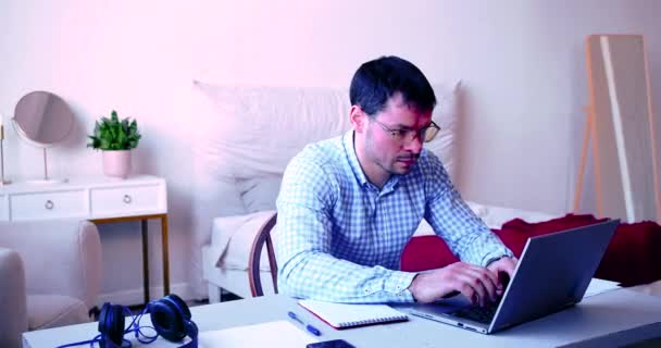 Fáradt férfi a laptop előtt otthon. Szabadúszó túldolgozó otthon koncepciója. - Felvétel, videó
