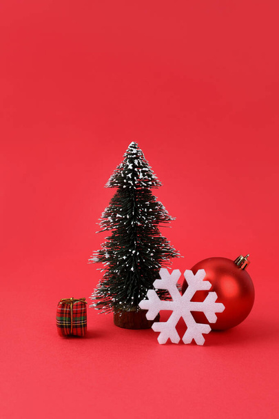 Karácsonyfa és díszek piros háttér - Fotó, kép