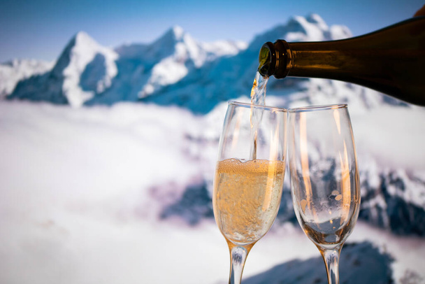 champagne glasses  and snowy peaks in background  New Year - Фото, изображение