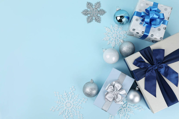 blue background with gift box, Christmas and snow ornaments - Фото, изображение