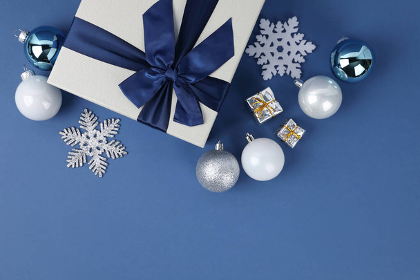 blue background with Christmas ornaments and ribbon and gift box - Fotó, kép