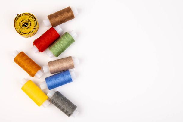 Detail of sewing thread with measure tape isolated on white background. Accessories of tailor or seamstress.  - Fotó, kép
