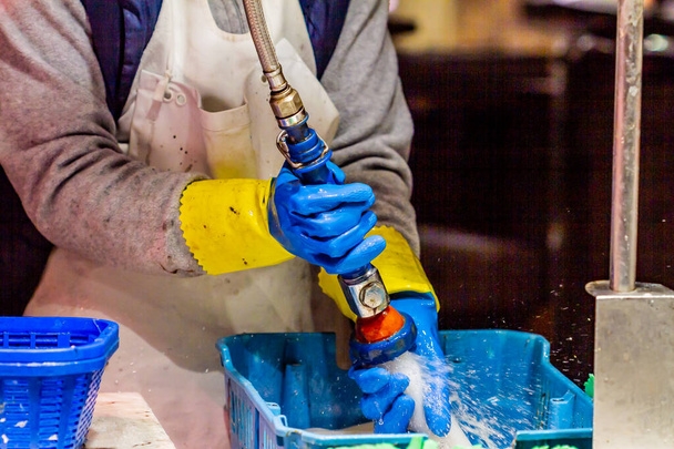 працівник очищає піч металевою трубою
 - Фото, зображення