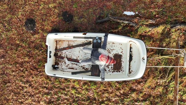 Letecký dron záběr rozesmátá žena sedí v člunu na souši - Fotografie, Obrázek