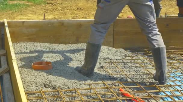 CLOSE UP: Contractors pour rough wet concrete over a reinforced steel net. - Footage, Video