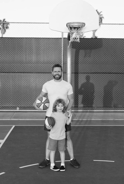 onnellinen isä ja poika lapsi pelata koripalloa pallolla leikkikentällä, isyys - Valokuva, kuva