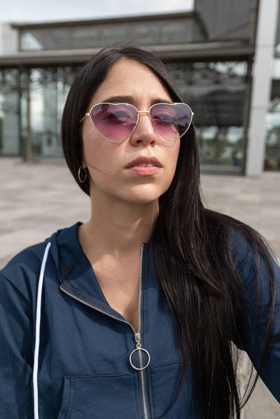 casual lifestyle of beautiful young latin woman with long straight black hair, natural face, wears casual jacket and heart shaped glasses, lifestyle, beauty and fashion - Фото, зображення