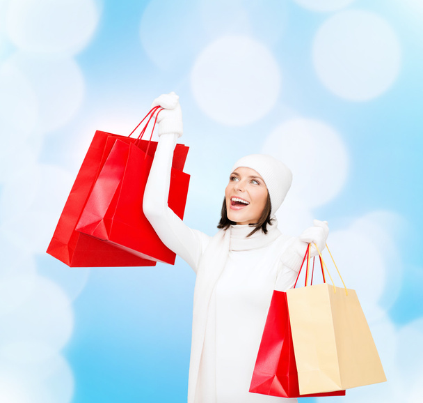 smiling young woman with red shopping bags - Foto, afbeelding