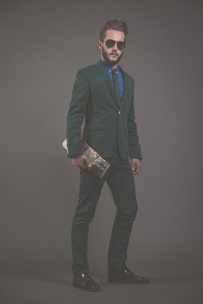 άνθρωπος των επιχειρήσεων μόδας φοράει πράσινο κοστούμι με τα γυαλιά ηλίου και μπλε - Φωτογραφία, εικόνα