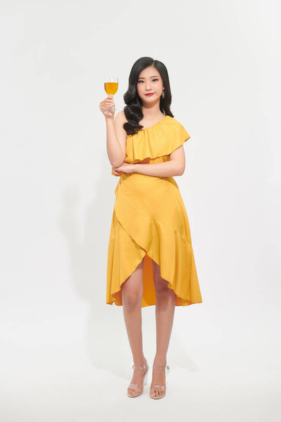 Charming beautiful woman with yellow luxury dress cheerful hand hold yellow wine glass drink in new year party festival concept - Фото, зображення