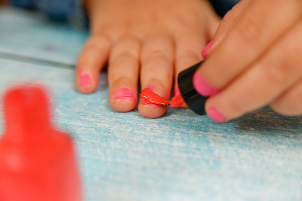Bir çocuğun ellerinde tırnak cilası. Çocuklar anne babalarının makyajını yaparlar.. - Fotoğraf, Görsel