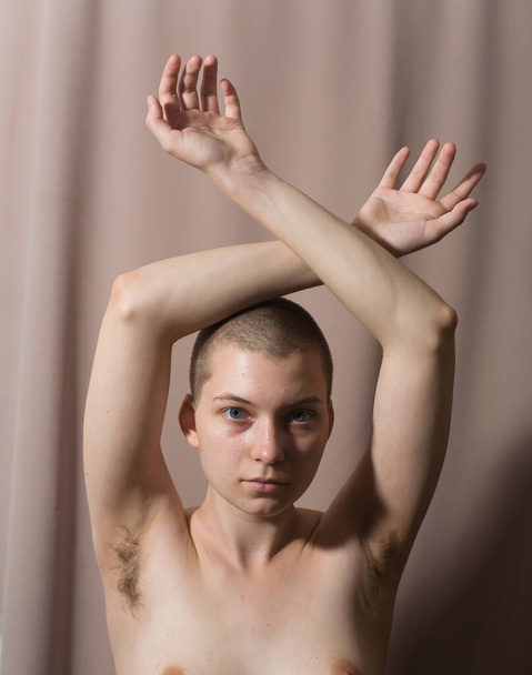 Young beautiful woman with naked elastic natural breasts and hairy armpits. Natural beauty. - Foto, afbeelding