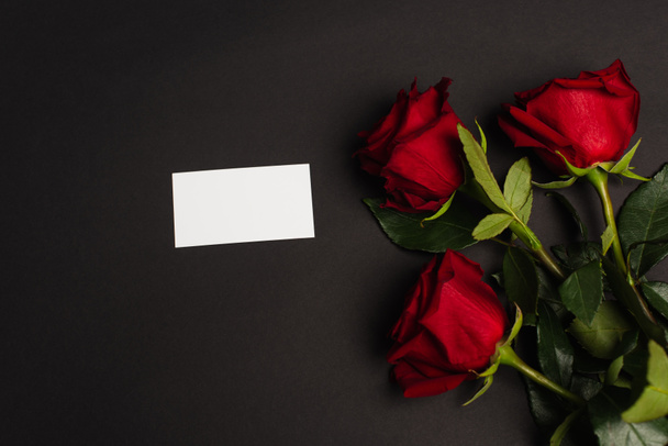 ylhäältä näkymä punaisia ruusuja lähellä tyhjä kortti musta - Valokuva, kuva