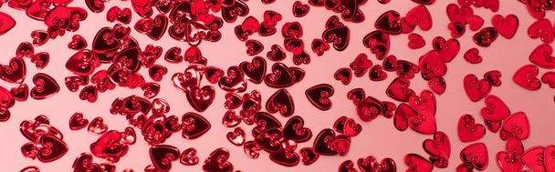 top view of shiny red confetti hearts on pink, banner - Fotoğraf, Görsel