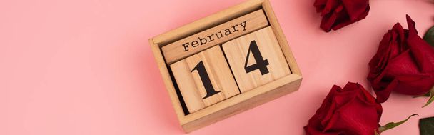 vue du haut des roses rouges près du calendrier avec lettrage 14 février sur rose, bannière - Photo, image