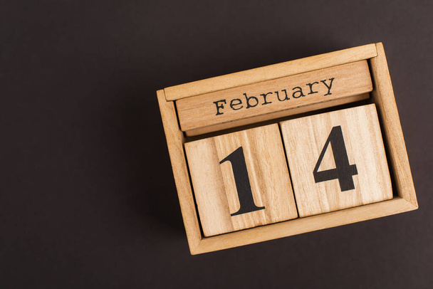 primer plano del calendario de madera con cubos y 14 letras de febrero en negro - Foto, imagen