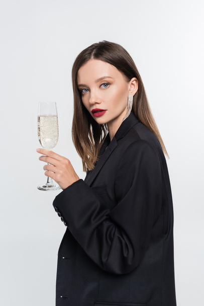 young brunette woman with champagne glass looking at camera isolated on grey - Foto, Imagen