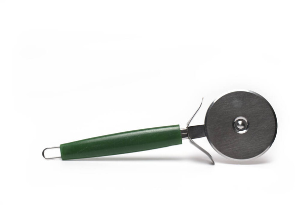 Close up of pizza cutter for rolling with cutting wheel and green handle isolated on white background - Photo, Image