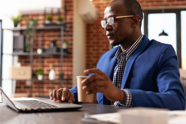 Африканський американець використовує ноутбук за столом, щоб планувати бізнес-стратегію. - Фото, зображення