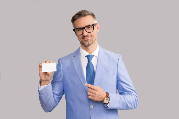 smiling mature man in glasses pointing finger on credit card and thumb up, copy space, call me - Foto, immagini