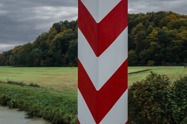 STAATSBORDERPOST - Die polnische Grenze ist mit Pfosten in den Nationalfarben gekennzeichnet  - Foto, Bild