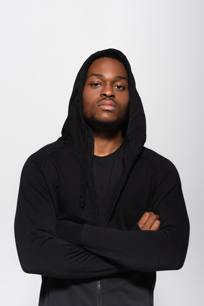 young african american man in hoodie standing with crossed arms isolated on grey - Fotografie, Obrázek
