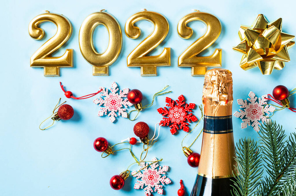 Şampanya şişesi ve dekorlu 2022 numara. Mutlu yıllar ve festival konsepti. Üst yatay görünüm, telif uzayı. Yeni Yıl 'da. Noel beşiği. Yeni yıl 2022. Yeni yıl kavramı. - Fotoğraf, Görsel