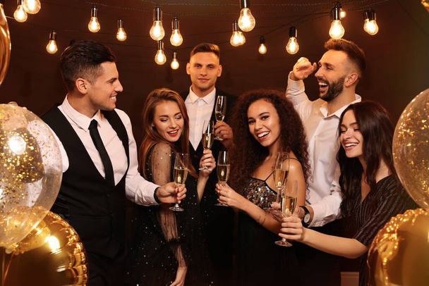 Happy friends with glasses of sparkling wine celebrating New Year indoors - Foto, Imagem