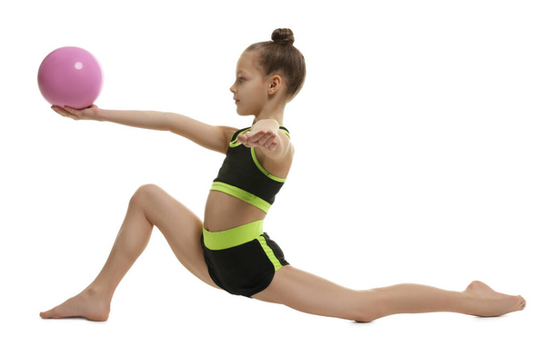 Cute little girl with ball doing gymnastic exercise on white background - Photo, image