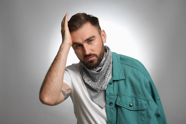 Fashionable young man in stylish outfit with bandana on grey background - Φωτογραφία, εικόνα