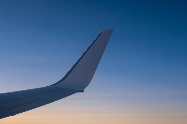 Полет и путешествия, вид из окна самолета на крыло на закате
. - Фото, изображение