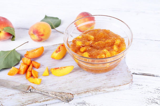 tasty peach jam with fresh peaches on wooden table - Photo, Image